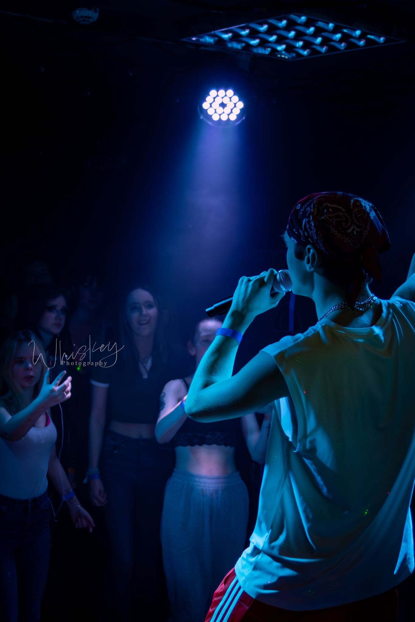 SHDE at a gig with blue lighting, facing the crowd.